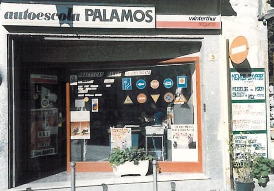 Fachada del local original de Autoescuela Palamós con señales de tráfico expuestas